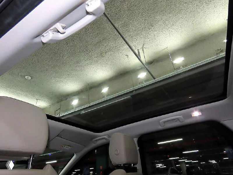 Панорамный люк и потолочная часть салона Land Rover Discovery Sport, видна внутренняя отделка крыши и крепления освещения салона.