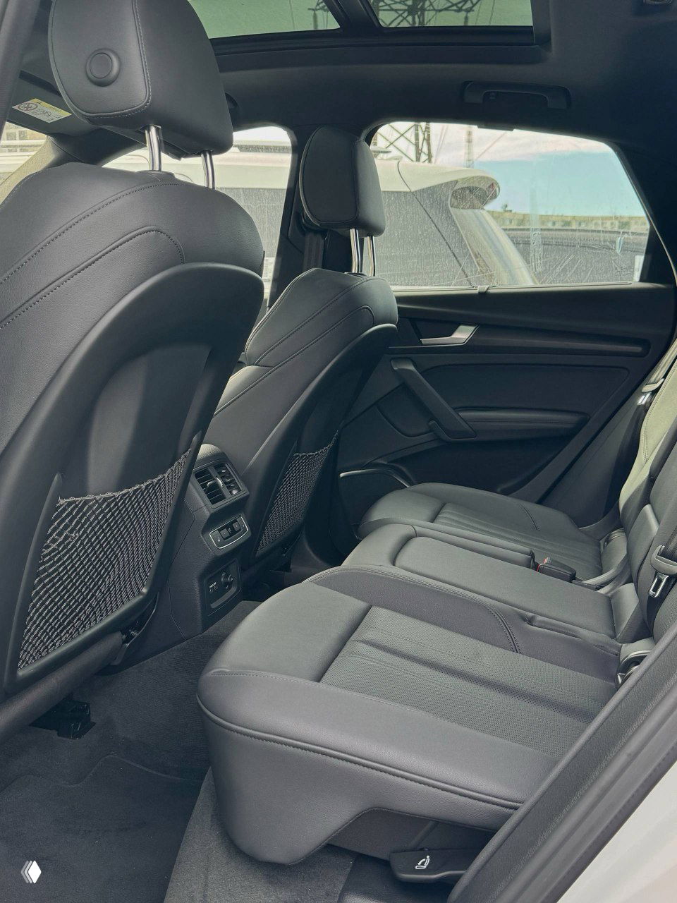 Задние сиденья Audi Q5 — пространство для пассажиров, сетки на спинках передних сидений, дефлекторы вентиляции и общий вид заднего ряда.