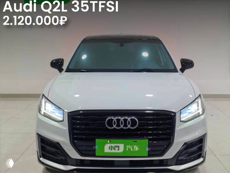Фото Audi Q2L 35TFSI 2021 года спереди в светлом гараже; видно оформление передней части и указание одного окраса, цена на снимке 2.120.000₽.