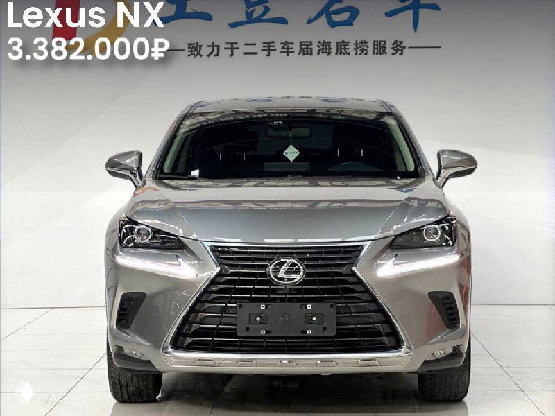 Серебристый Lexus NX 2021 года фронтальным видом в выставочном зале, видна решётка радиатора и цена 3.382.000₽.
