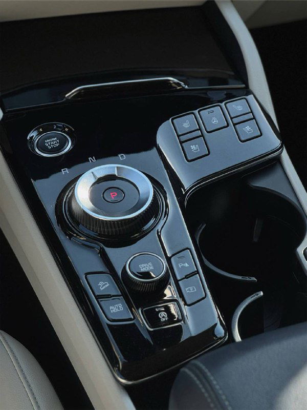 Блок управления и селектор в центральной консоли KIA Sportage — шайба селектора, кнопки режимов и глянцевая отделка вокруг.