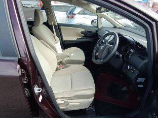 Переднее пассажирское место Toyota Wish: открытая дверь, светлая тканевая обивка сиденья, обзор на пространство переднего ряда и состояние обивки.