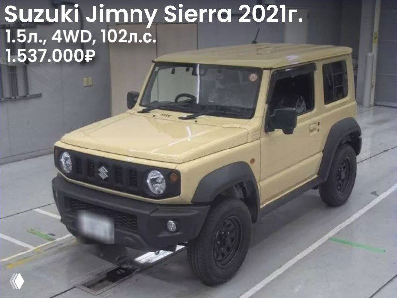Фото Suzuki Jimny Sierra 2021: бежевый внедорожник 4WD, вид спереди в ангаре аукциона; пол и разметка площадки видны, номера скрыты.