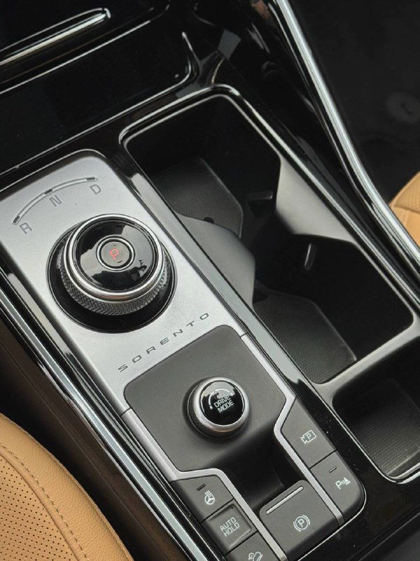 Блок управления селектором трансмиссии, подстаканники и элементы центральной консоли KIA Sorento 2022 крупным планом — отделка и эргономика.