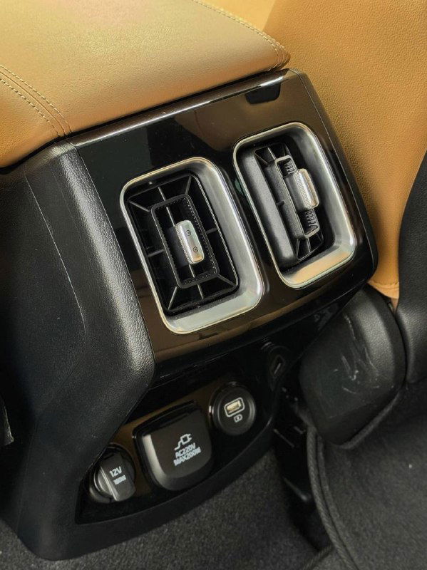 Воздуховоды и разъёмы питания на задней панели центральной консоли KIA Sorento 2022 — вид на мелкие функциональные элементы для пассажиров.