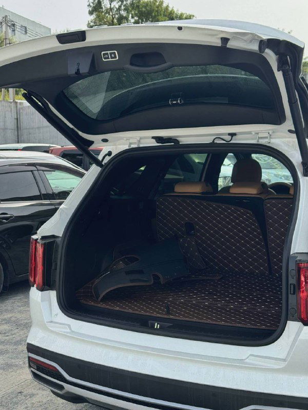 Открытый багажник белого KIA Sorento 2022 с видимым ковриком и объёмом грузового отсека — демонстрация практичности багажного отделения.