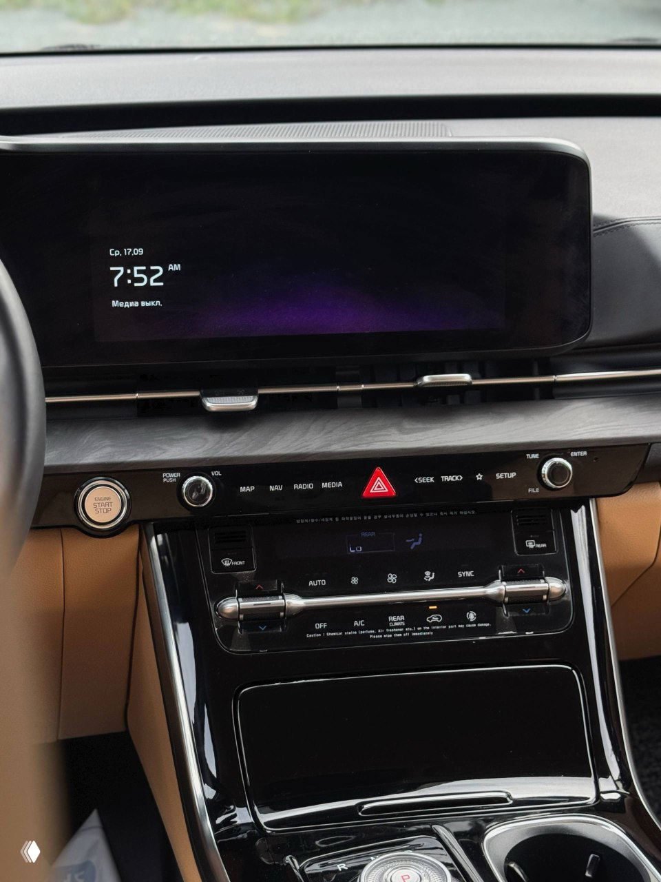 Панель приборов и большой центральный дисплей мультимедиа в салоне KIA Carnival, чёрная отделка и элементы управления климатом.