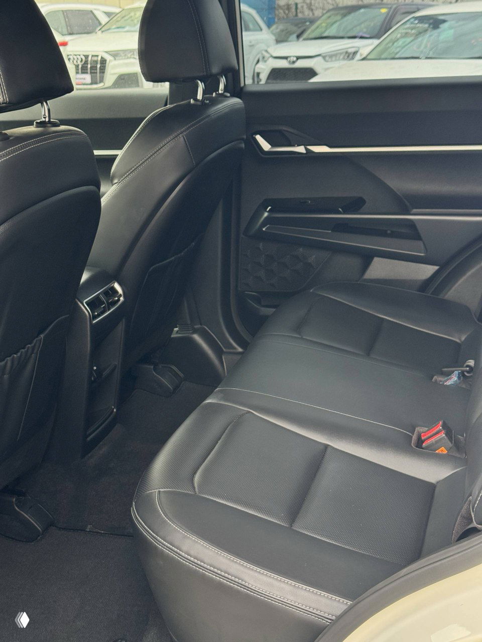 Задний ряд сидений SsangYong Torres: чёрная кожаная обивка, пространство для ног и вид на заднюю часть передних сидений.