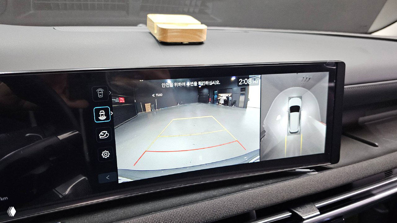 Камеры и система обзора 360° на экране мультимедиа Hyundai Tucson 2025: изображение задней камеры с разметкой парковки и обзор сверху автомобиля.