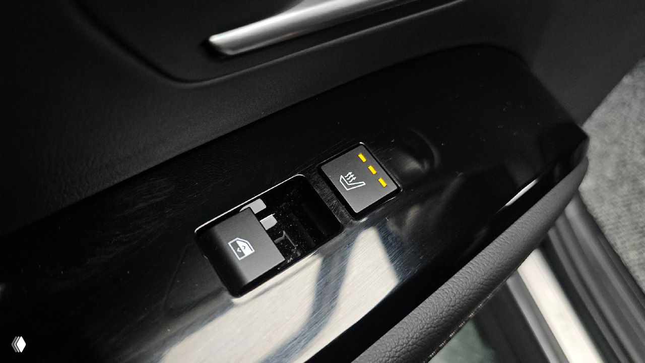 Крупный план кнопки подогрева и управления стеклоподъёмником на водительской двери Hyundai Tucson 2025; видны индикаторы нагрева и материал панели.