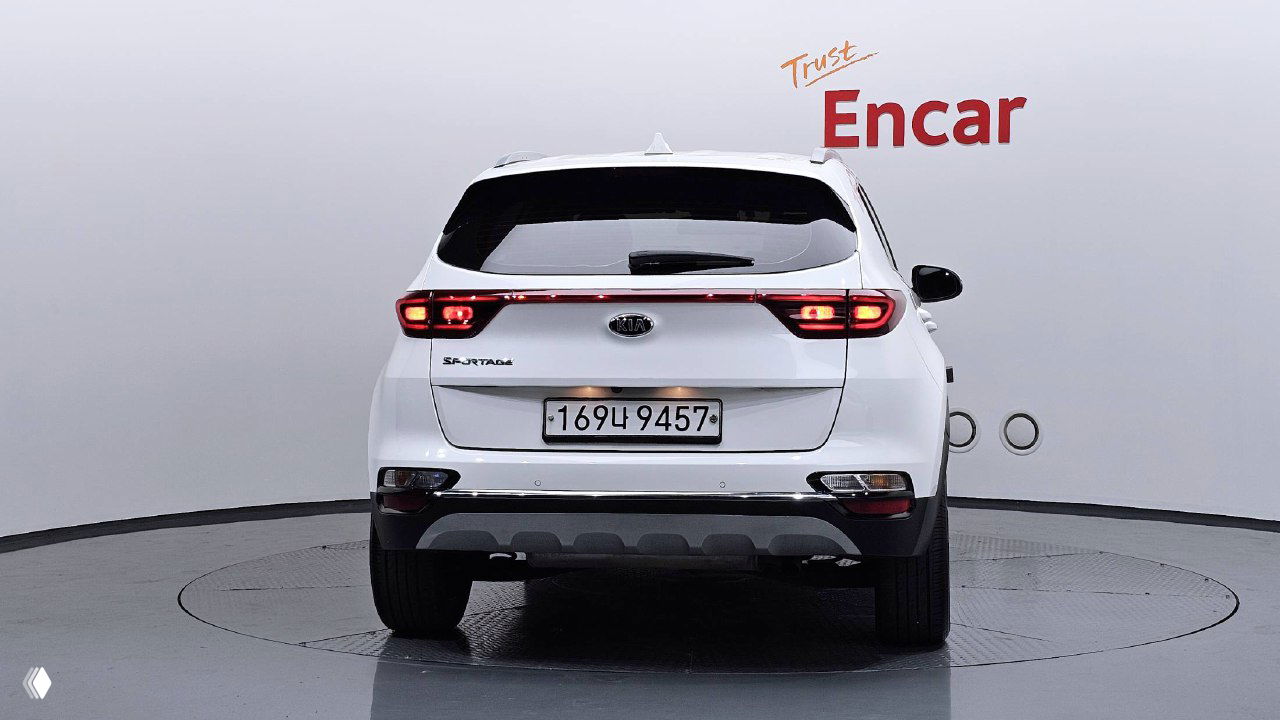 KIA Sportage, вид сзади в студии: белый кузов, номерная табличка Южной Кореи, целая задняя оптика и багажник закрыт.