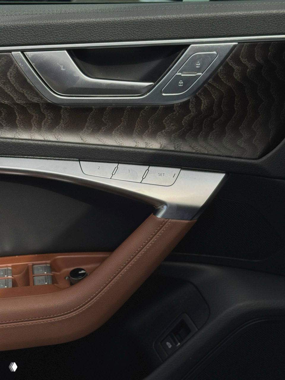 Деталь дверной панели Audi A6: кнопки памяти сидений, ручка двери и декоративные вставки, вид крупным планом.