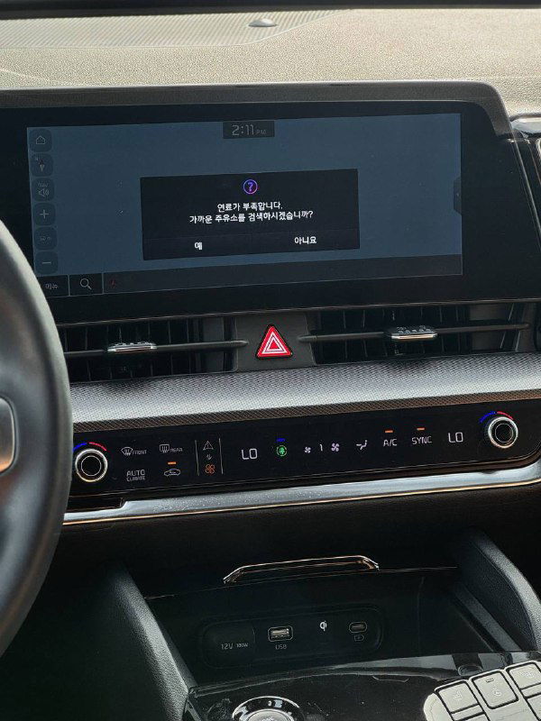 Панель передней части салона KIA Sportage с центральной консолью и климат-контролем: кнопки управления и ЖК-индикация в интерьере автомобиля.