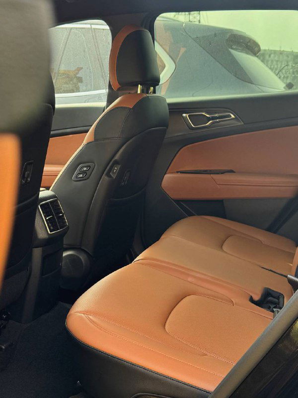 Задние сиденья KIA Sportage в коричневой обивке, вид под углом: комфортная посадка, подголовники и часть задней вентиляции внутри салона.