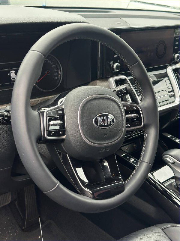 Рулевое колесо и панель KIA Sorento 2020 — вид салона, кожаная отделка руля, кнопки управления и приборная панель вблизи.