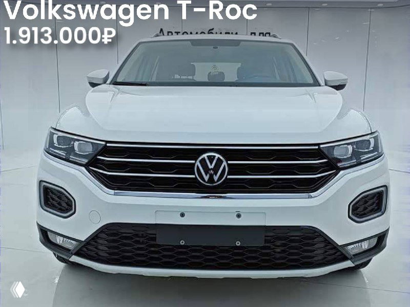 Фронтальный вид белого Volkswagen T‑Roc Comfort Plus; видна цена 1.913.000₽, автомобиль на площадке импорта без окрасов.