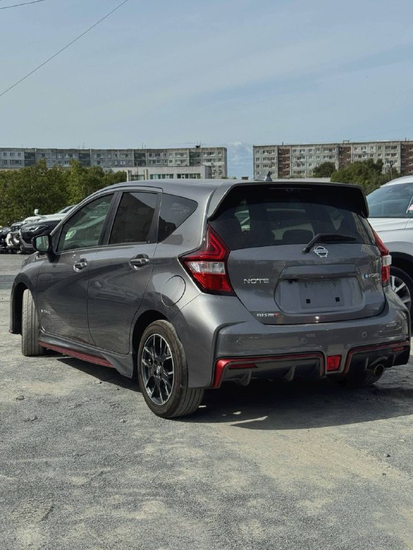 Задняя часть Nissan Note Nismo ePower 2017, вид со стороны кормы — серый кузов, спортивный бампер и задняя оптика, автомобиль стоит на асфальте в автосейле.
