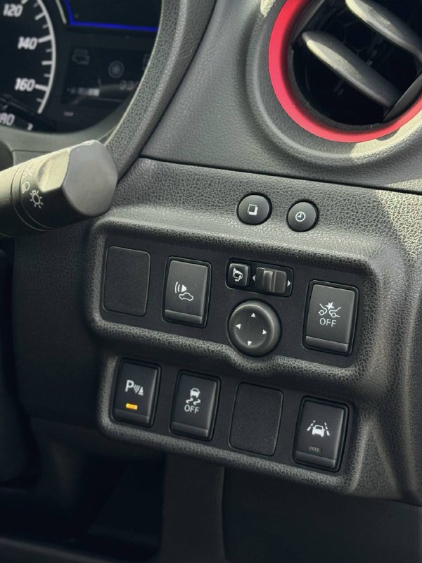 Блок кнопок и панель слева от руля Nissan Note Nismo ePower: кнопки ассистентов, управления зеркалами и прочие органы управления, крупный план с видимыми индикаторами.