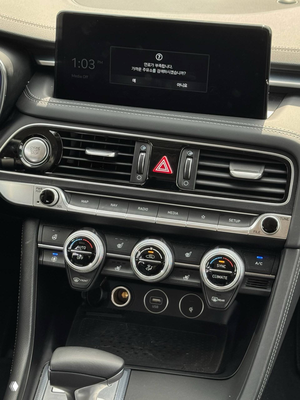 Крупный план центральной консоли Genesis G70: мультимедиа экран, регуляторы климата и элементы управления, фото для проверки состояния салона при импорте.