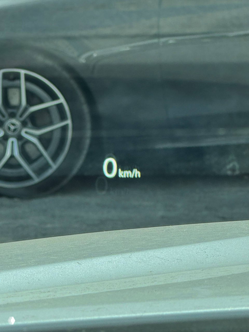 Проекция HUD на лобовом стекле Genesis G70 с отображением скорости 0 km/h, частичный вид колеса и поверхности вокруг автомобиля для отчёта о состоянии.