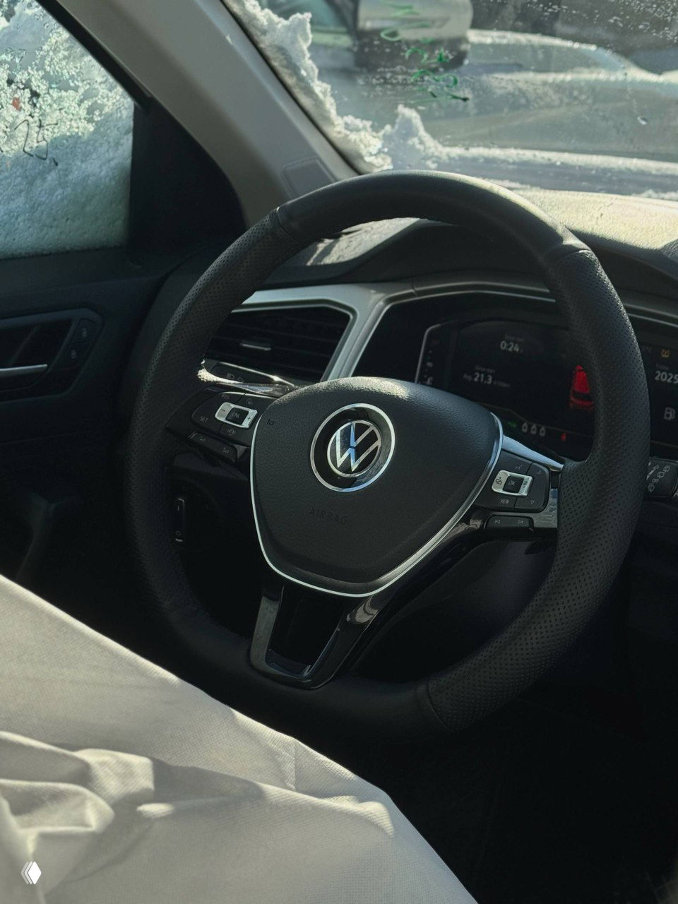 Рулевое колесо Volkswagen с логотипом на фоне цифровой приборной панели — интерьер автомобиля перед выдачей клиенту.