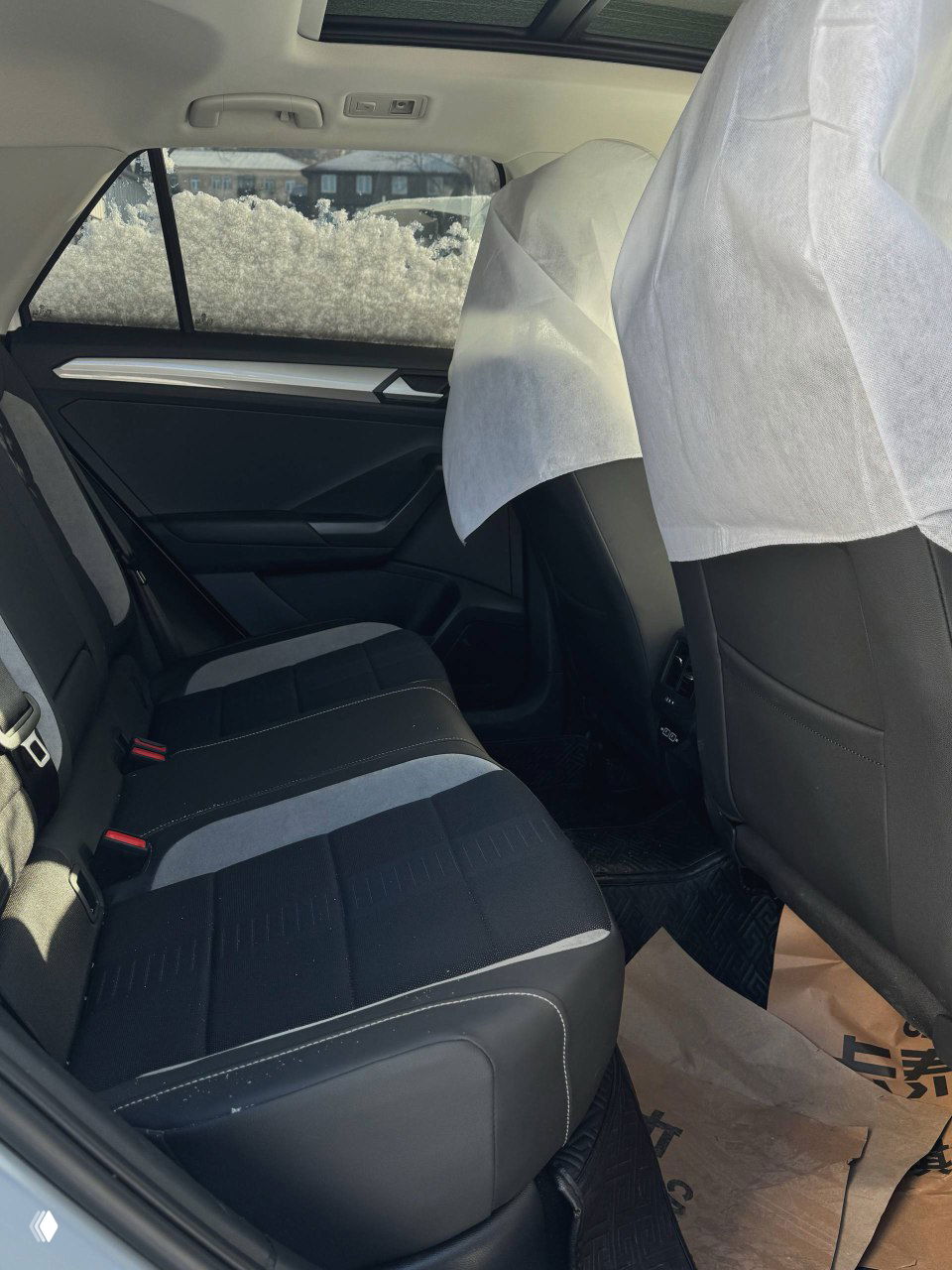 Задний ряд сидений Volkswagen T‑ROC — тканевые сиденья, ремни безопасности и пространство для пассажиров в салоне.