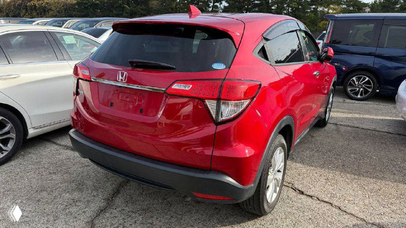 Задний ракурс красного Honda Vezel 2020 на парковке, видны багажник, задние фонари и бампер, состояние кузова без госномера.