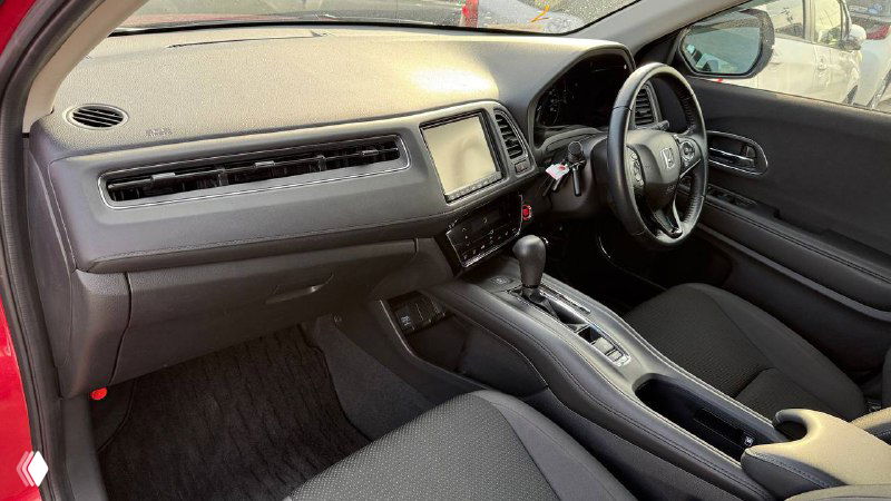 Интерьер Honda Vezel 2020, вид на передние сиденья, центральную консоль и панель приборов, состояние обивки и отделки салона.