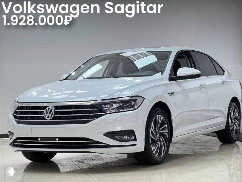 Фотография белого Volkswagen Sagitar 2022 года в торговом зале; вид спереди и сбоку, заметны фары, решётка и декоративные элементы кузова вместе с ценой и пробегом.