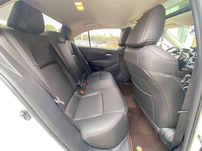 Задние сиденья Toyota Corolla 2023: пространство для пассажиров, ремни безопасности и пол с резиновыми ковриками, салон в ухоженном состоянии.