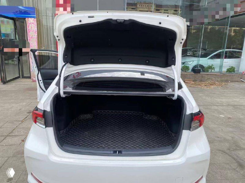 Открытый багажник белой Toyota Corolla 2023 года; видна грузовая ниша и резиновый коврик, багажник чистый и без повреждений.