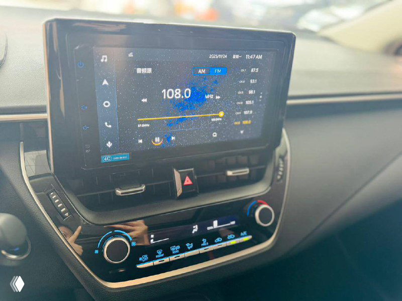 Крупный план мультимедийной панели Toyota Corolla 2022 с включённым дисплеем и элементами управления климатом в салоне автомобиля.