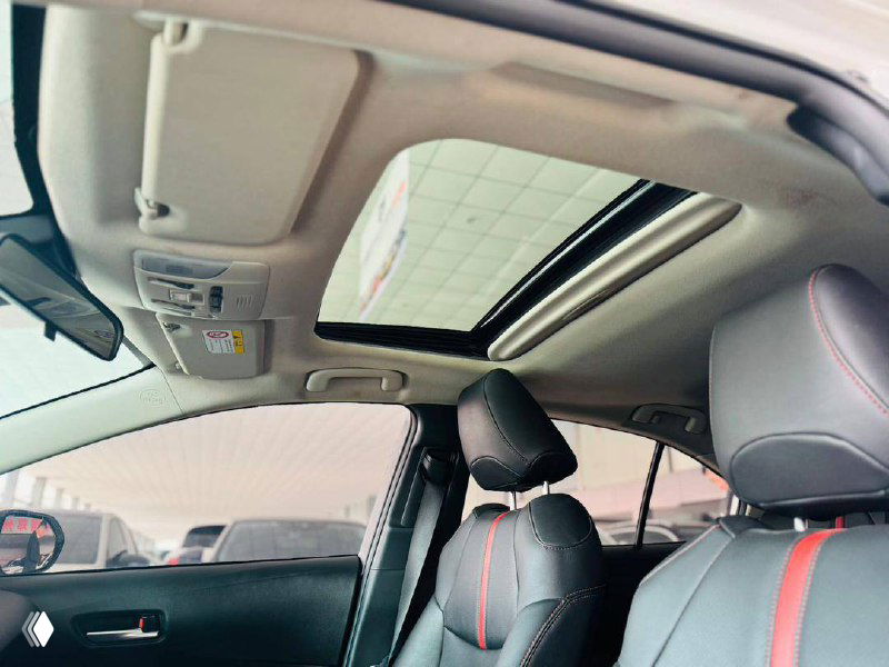 Вид потолка и панорамного люка Toyota Corolla 2022 — открытый люк, верхняя часть салона и солнцезащитные козырьки видны на фото.
