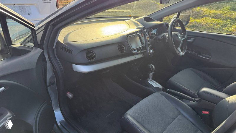 Фотография салона Honda Insight 2011 спереди: центральная консоль, пассажирское и водительское сиденья, материалы отделки и торпедо.