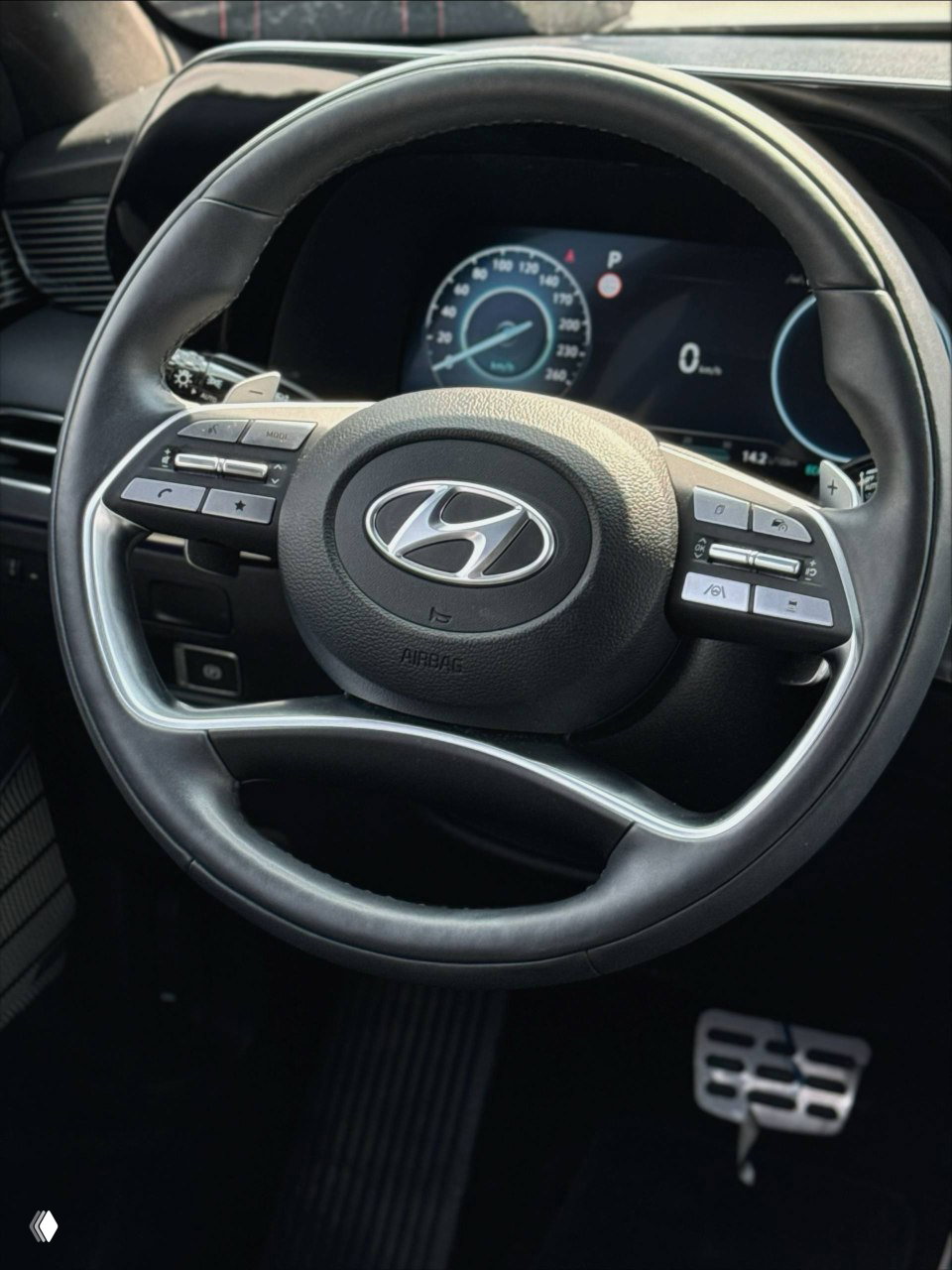 Крупный план рулевого колеса Hyundai Palisade с видимым логотипом, кнопками управления и кожаной отделкой — демонстрация салонной фурнитуры и качества руля.