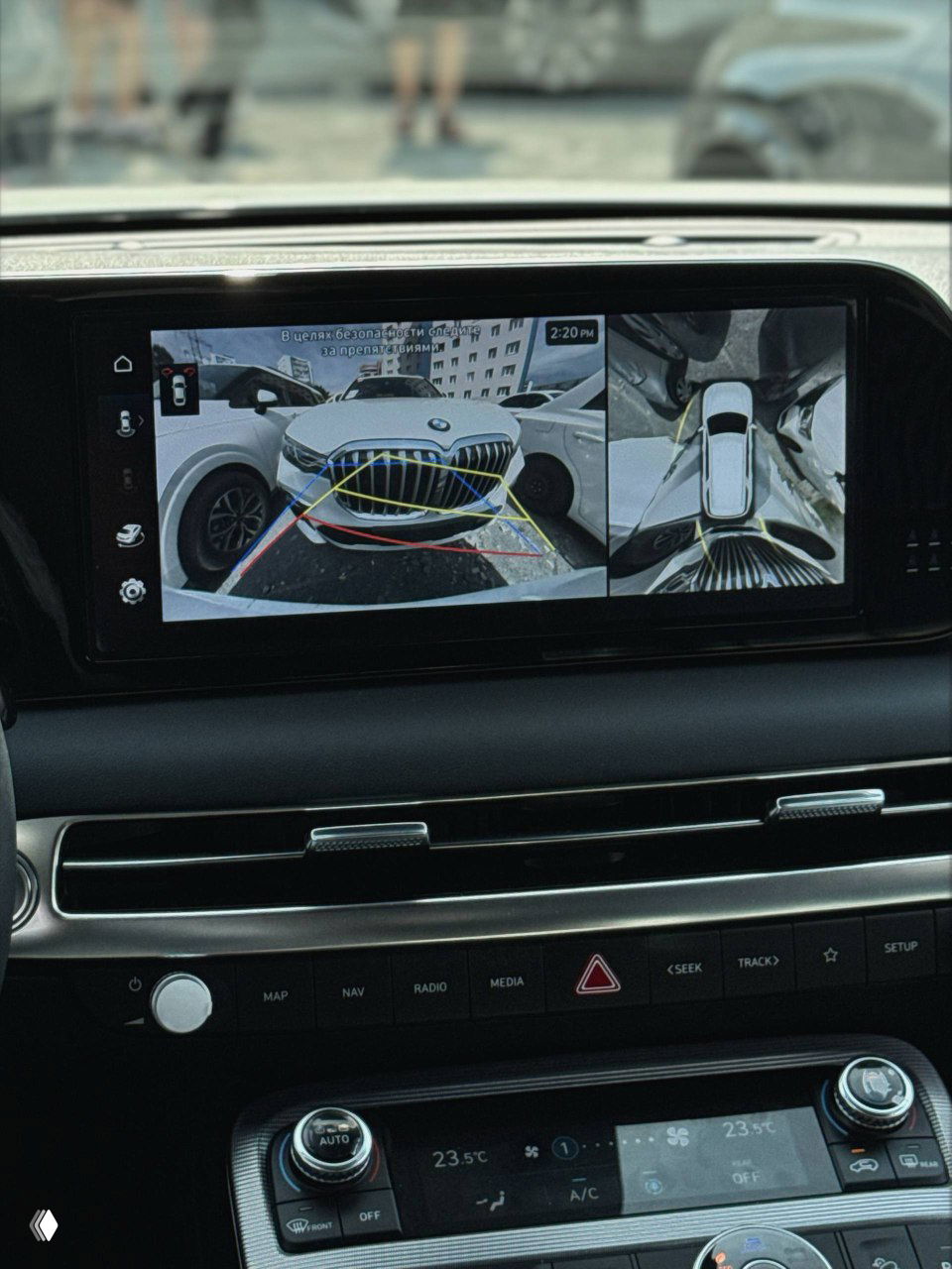 Экран мультимедиа с изображением камеры заднего вида и кругового обзора — показаны линии парковки, видимость камер и интерфейс системы помощи при парковке.