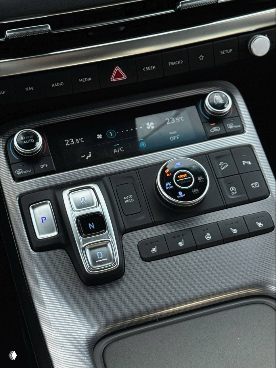 Центральная консоль Hyundai Palisade: панель климата, мультимедиа и элементы управления — видно расположение кнопок, поворотный регулятор и отделку передней панели.