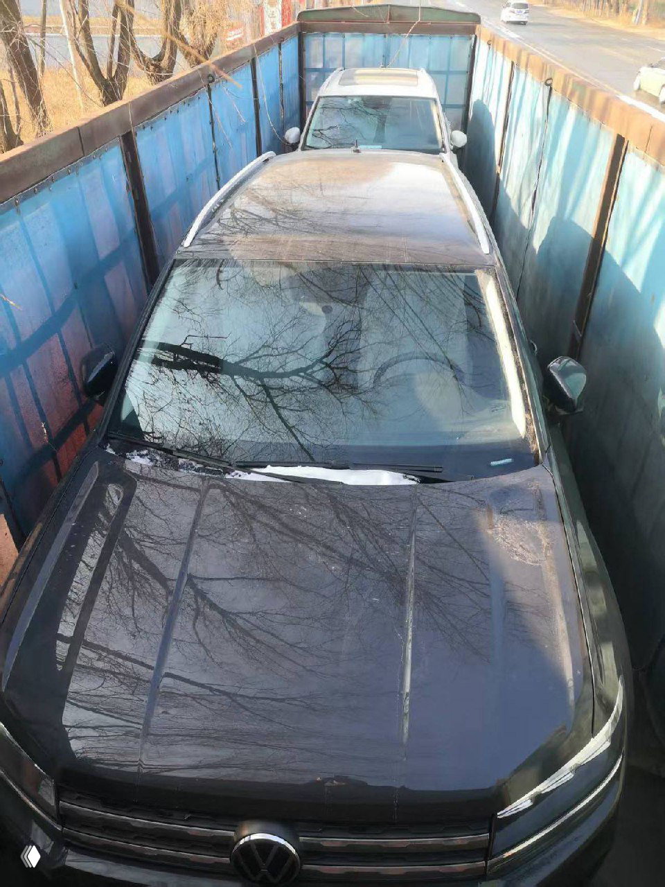 Два автомобиля Volkswagen Tharu внутри грузового контейнера с высоты — сцена погрузки для морской перевозки в Россию.