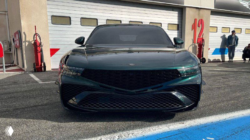 Передняя часть зелёного Genesis G90 Wingback крупным планом, широкая решётка и узкие фары подчёркивают брутальный облик универсала.