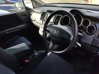 Салон Honda Crossroad 2008 — вид руля, приборной панели и передних сидений; фото сделано в процессе аукционного осмотра.