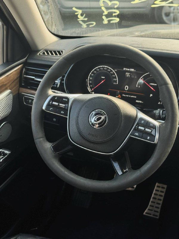 Руль и приборная панель KIA Mohave — крупный план салона: кожаный руль, спидометр и элементы управления на торпеде.