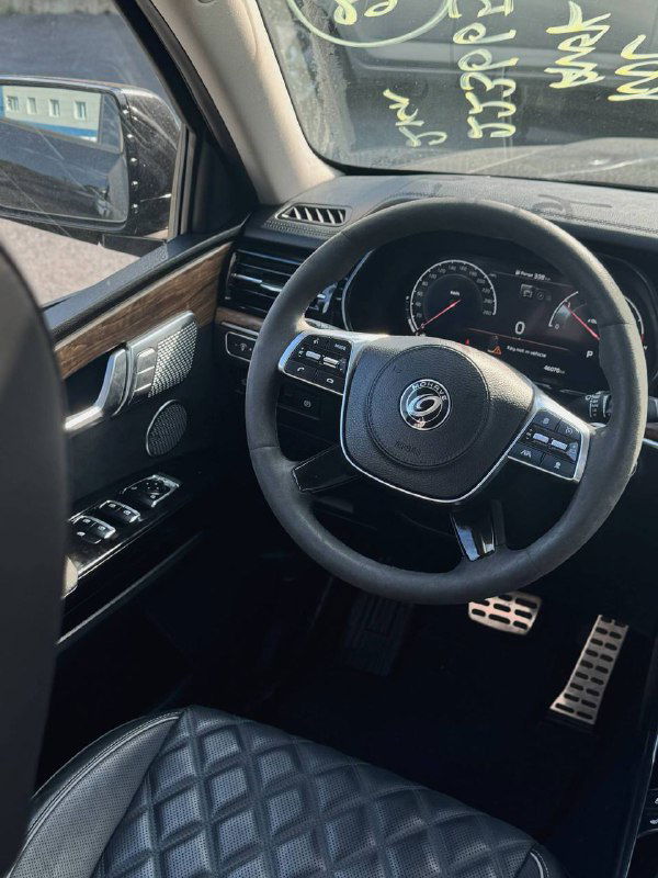 Водительское место: руль, панель управления и кресло с кожаной отделкой — крупный вид салона автомобиля KIA Mohave.