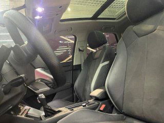 Передние сиденья Audi Q3 в профиль под панорамной крышей: материал обивки, боковая поддержка и общий вид салона.