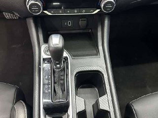 Фотография центральной консоли и селектора вариатора Nissan Sylphy 2022, видны подстаканники и отделка вокруг коробки передач.