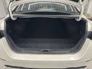 Фото открытого багажника Nissan Sylphy 2022, видно объём грузового отделения и состояние коврового покрытия в нише багажника.