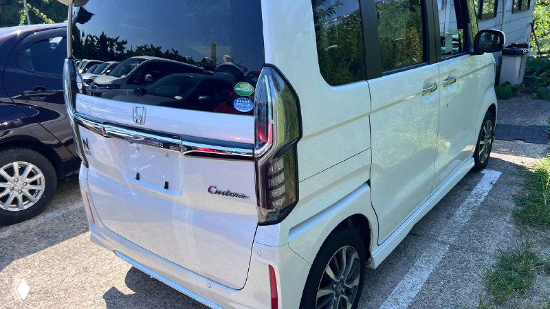 Задняя часть Honda N BOX CUSTOM: багажник, задние фонари и шильдик 'Custom' на парковке в Японии, фото состояния сзади.