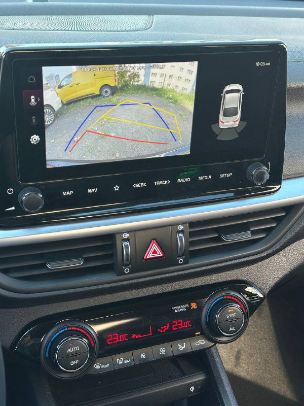 Сенсорный экран мультимедиа KIA K3 с изображением с камеры заднего вида и разметкой парковки, демонстрирует оснащение машины.