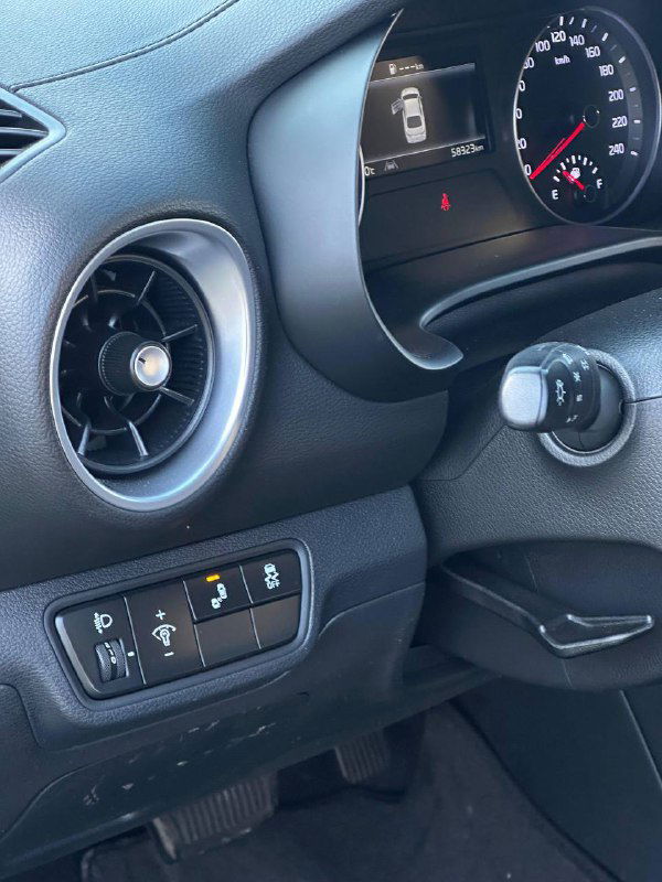 Панель приборов и блок управления слева от руля KIA K3, видны кнопки ассистентов и вентиляционное сопло на водительской стороне.