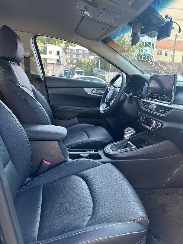 Вид передней части салона KIA K3 2022 с рулём, мультимедиа и центральной консолью, демонстрирующий интерьер и упаковку приборов.