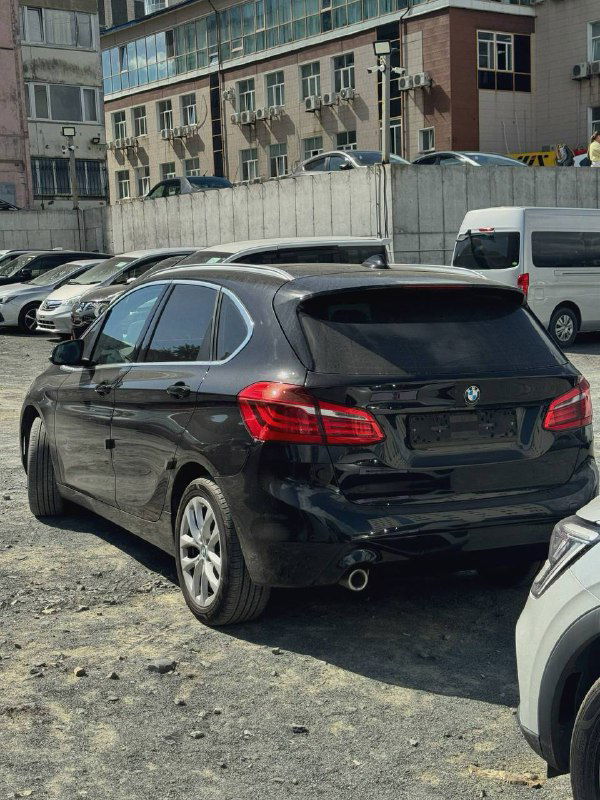 Задняя часть чёрного BMW 2-Series Active Tourer на стоянке: видны багажник, задние фонари, бампер и общие пропорции минивэна.